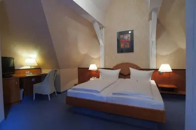 Ein Bett oder Betten in einem Zimmer der Unterkunft Hotel Schlossvilla Derenburg