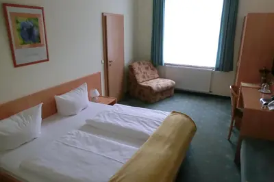 Ein Bett oder Betten in einem Zimmer der Unterkunft Hotel Garni am Schlosspark