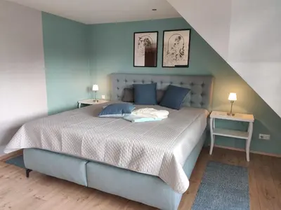 Ein Bett oder Betten in einem Zimmer der Unterkunft Ferienhaus Blaue Blume mit 11 kW Ladestation, Kamin, Terrasse, eingezäuntem Garten, Sauna, WLAN, Netflix, 2 Hunde willkommen!